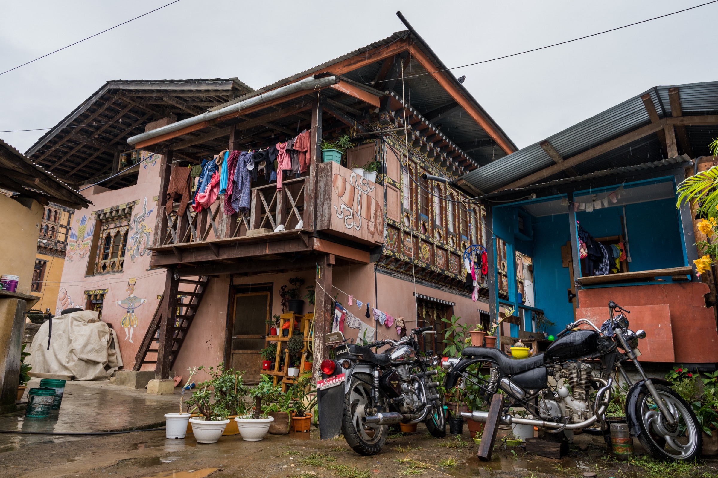 Motorcycle parked beside a traditional Bhutanese home
